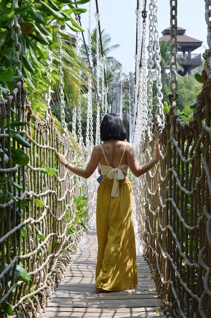 Photo rear view of woman walking on footbridge