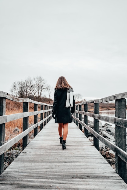 Foto vista posteriore di una donna che cammina su un ponte pedonale