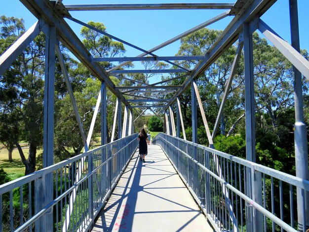 Photo rear view of woman walking on footbridge