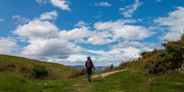 Foto vista posteriore di una donna che cammina su una collina contro il cielo