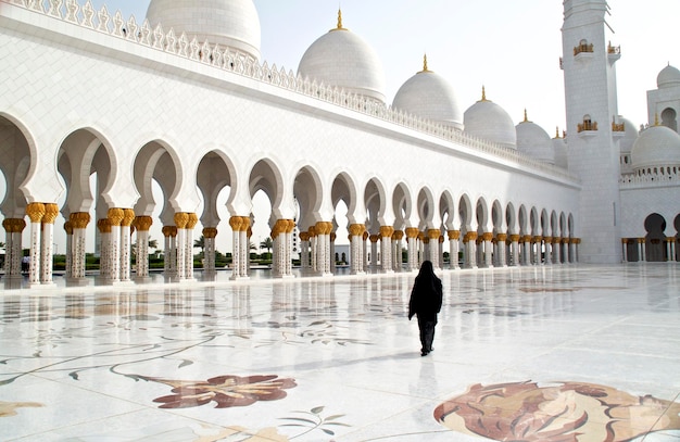 rear view of woman walking outside historic mosque