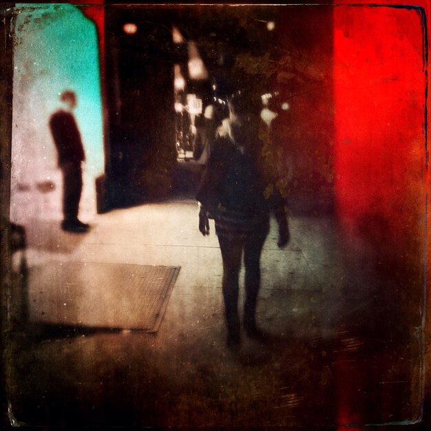 Foto vista posteriore di una donna che cammina sul sentiero di notte