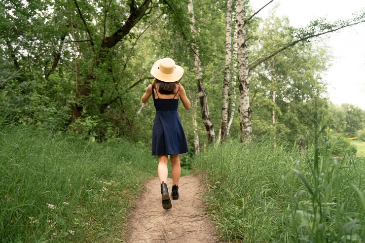 Photo rear view of woman walking on road amidst trees
