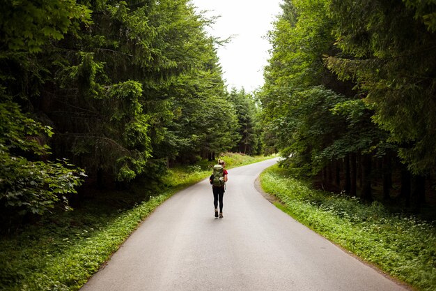 Photo rear view of woman walking on road amidst trees