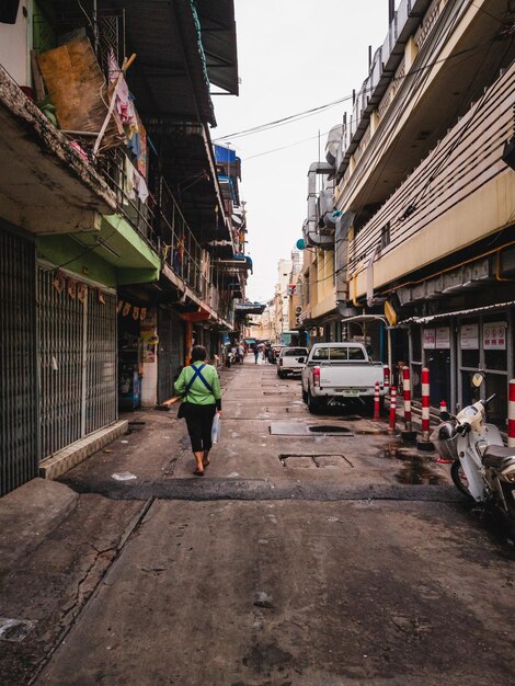 Photo rear view of woman walking on street amidst buildings in city