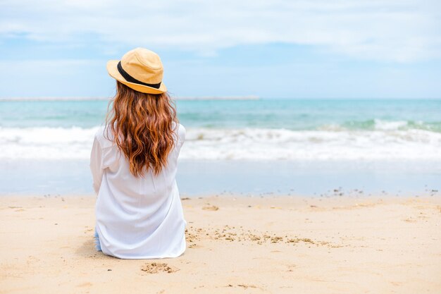 Rear view of woman wearing hat on beach