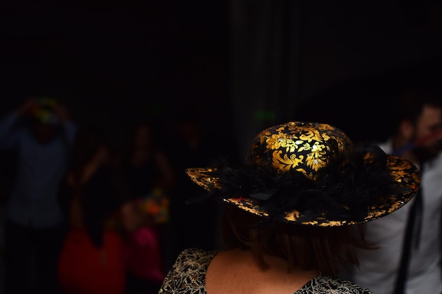 Photo rear view of woman wearing hat at night