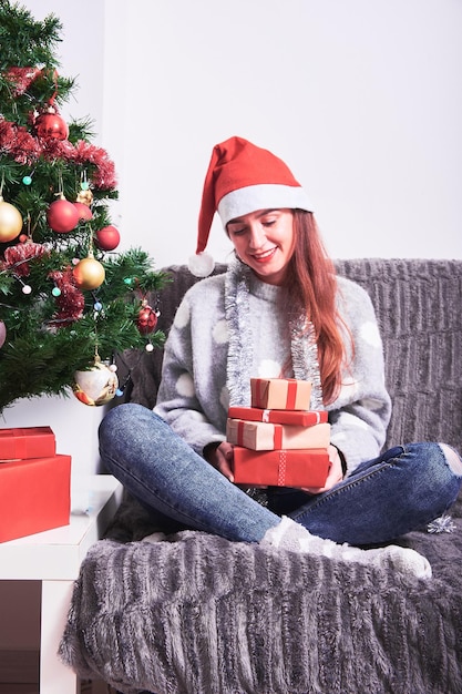 クリスマスツリーに座っている帽子をかぶった女性の後ろの景色