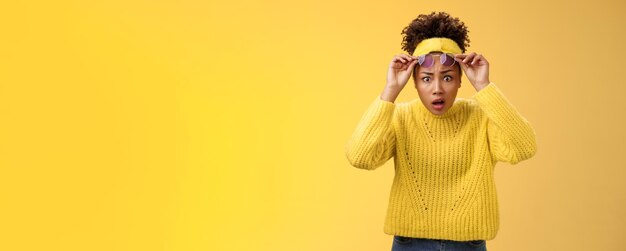 Photo rear view of woman wearing hat standing against yellow background