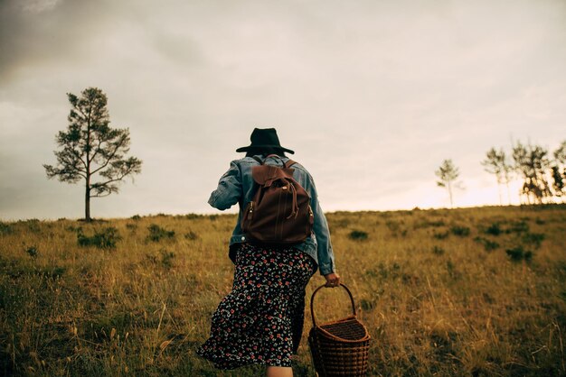 Rear view of woman wearing hat standing on field