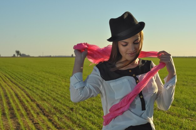 Rear view of woman wearing hat standing on field