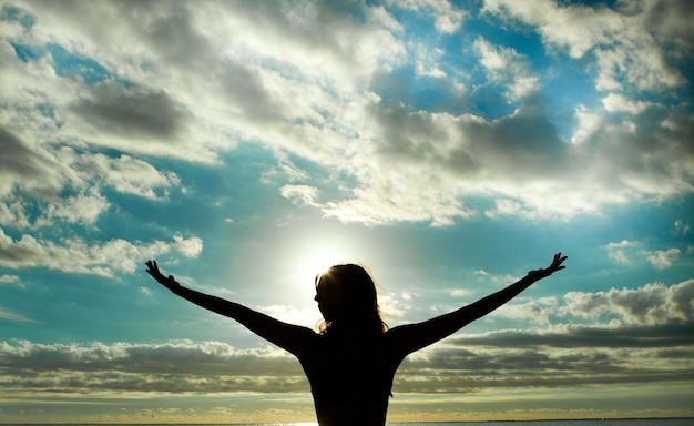 Photo rear view of woman with arms outstretched against cloudy sky