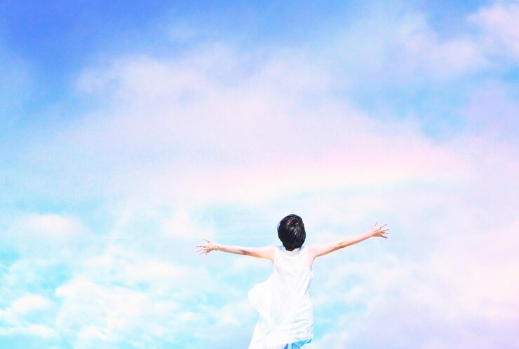 Photo 空に向かって腕を伸ばした女性の後ろの景色