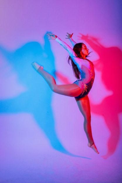 Rear view of woman with arms raised against blue background