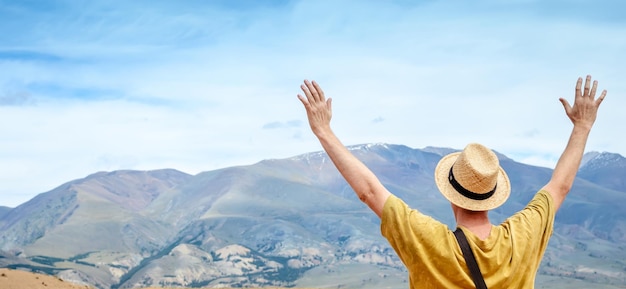 Rear view of woman with arms raised against sky