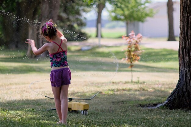 Foto vista posteriore di una donna con le braccia alzate nel parco