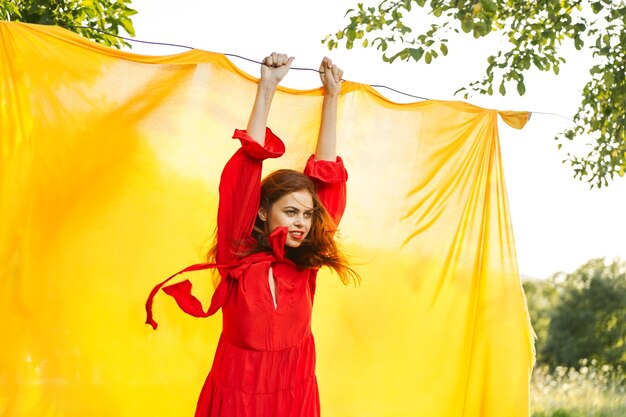 Rear view of woman with arms raised standing against trees