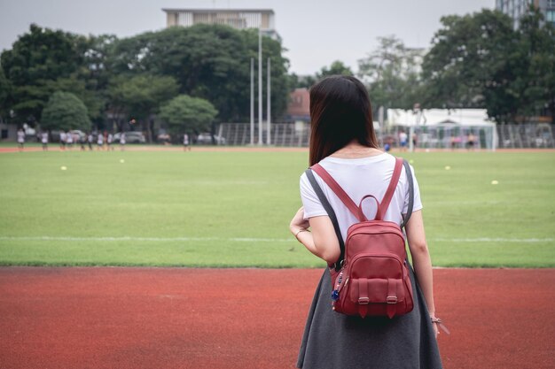 Rear view of woman with backpack at court