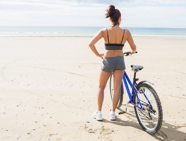 해변에서 자전거를 가진 여자의 뒷 모습