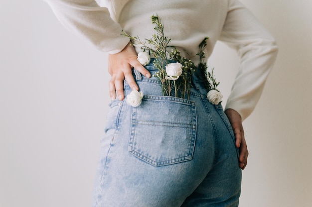 Rear view of woman with flowers in pockets