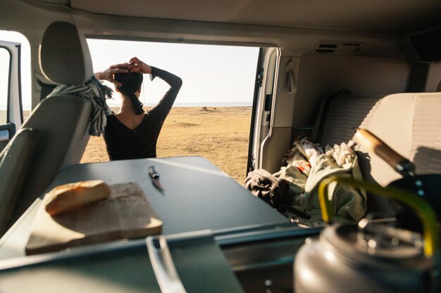 Foto vista posteriore di una donna con la mano nei capelli vista anche se in camper