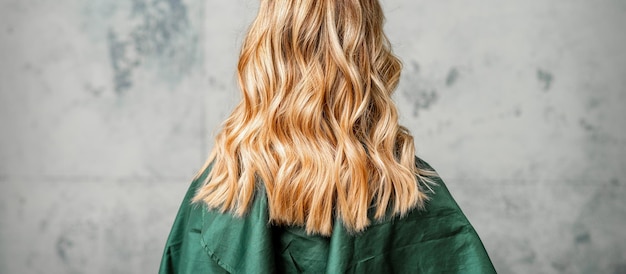 Rear View of a woman with long brown hair against a gray background.