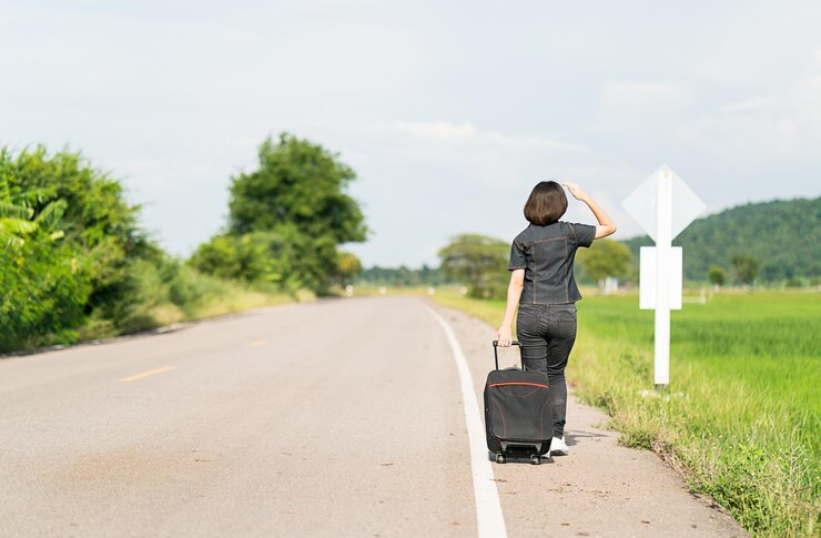 Photo 空の向こうの道路で荷物を持った女性の後ろの景色