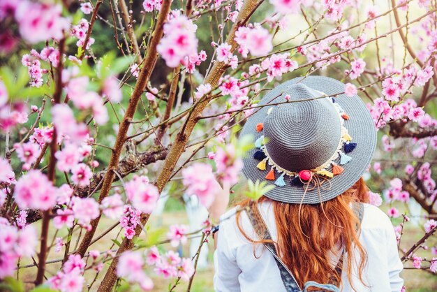 ピンクの花を飾った女性の後ろの景色