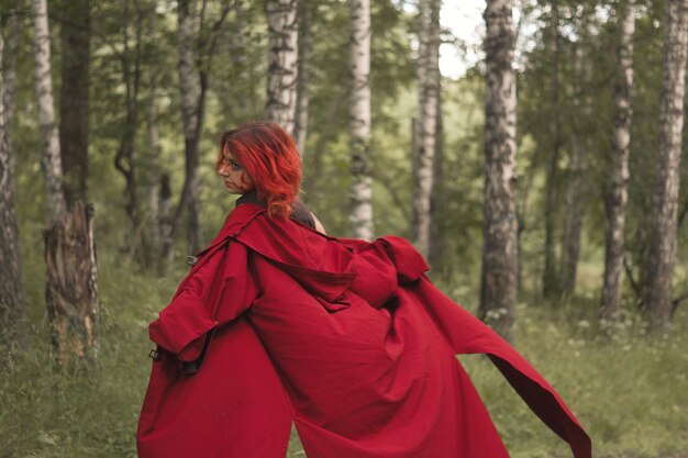 Photo rear view of woman with red umbrella in forest