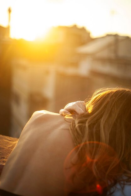 Photo rear view of woman with umbrella against sky during sunset