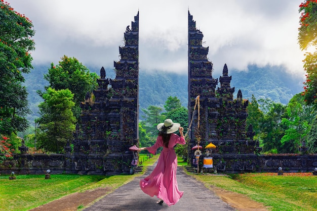 天空を背景に傘をかぶった女性の後ろの景色