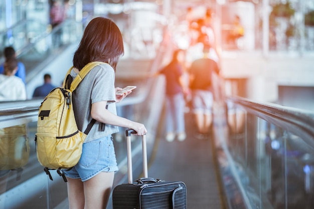 傘を持った女性が街を歩いている後ろの景色