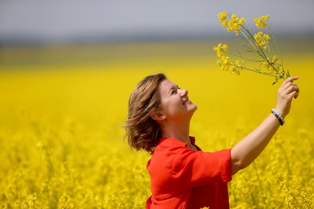 Rear view of woman with yellow flower in field