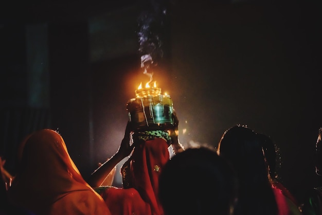 夜に伝統的な祭りを祝う女性の後ろの景色
