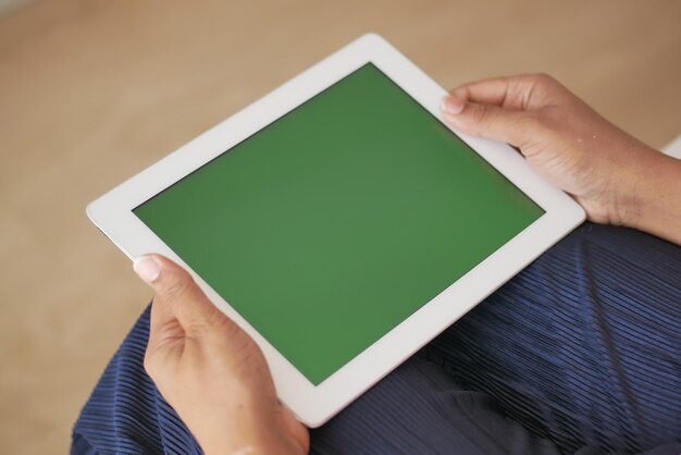 Rear view of women hand using digital tablet with green screen