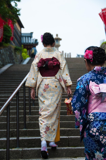 Foto vista posteriore di donne in kimono che camminano sui gradini