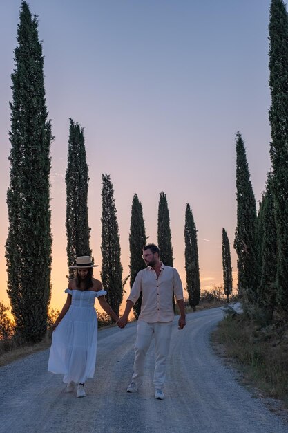 Photo rear view of women walking on road along trees