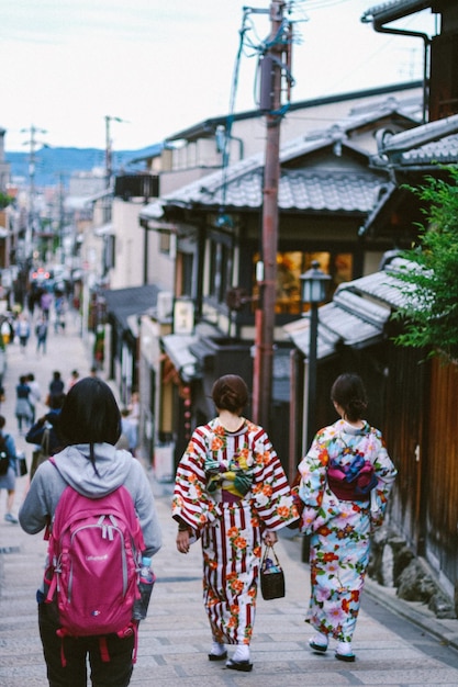 Rear view of women walking on street in city