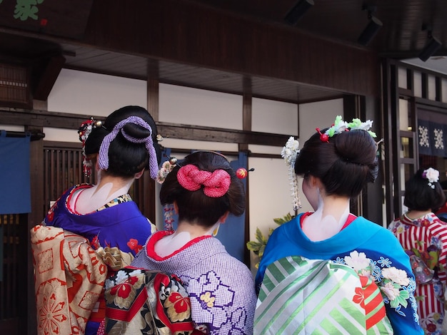 Rear view of women with woman in traditional japanese clothing