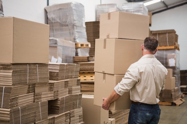 Rear view of worker carrying boxes