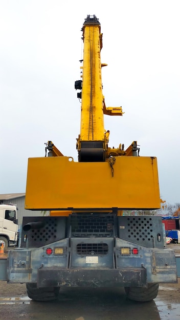 Rear view of yellow mobile crane boom up