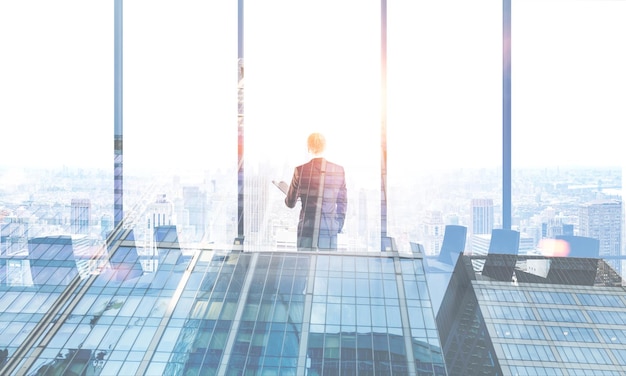 Rear view of a young businessman looking in a panoramic window of a modern office meeting room. Skyscraper in the foreground. 3d rendering mock up toned image double exposure
