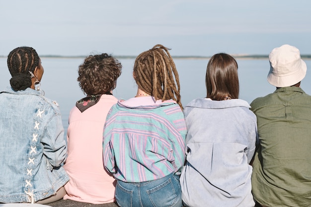 Foto vista posteriore di giovani amici interculturali in abbigliamento casual