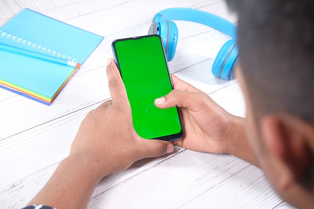 Rear view of young man using smart phone indoor