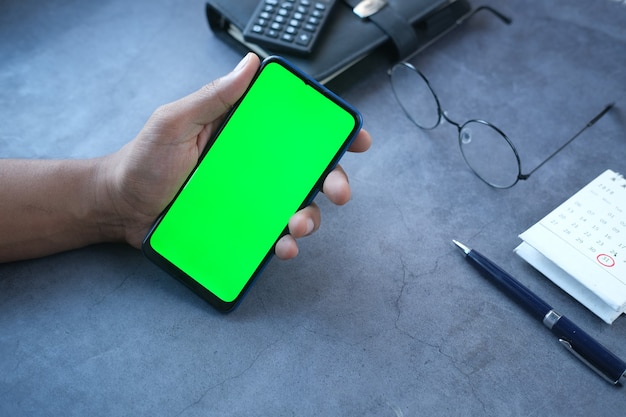 Rear view of young man using smart phone on table