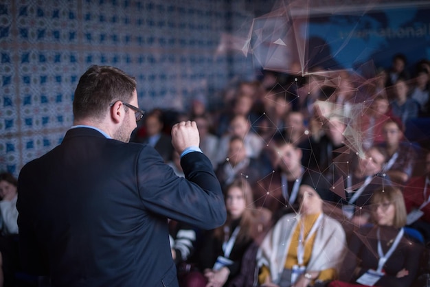 Photo rear view of young successful businessman at business conference room with public giving presentations. audience at the conference hall. entrepreneurship club