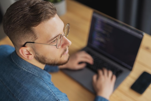 Photo rear view of young thoughtful coder