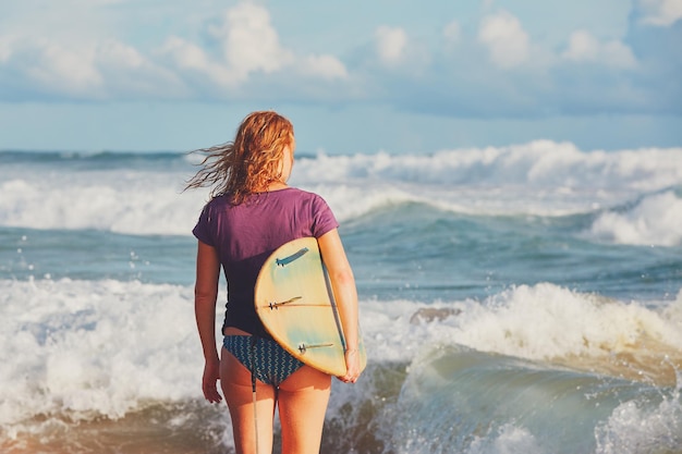 rear view of young woman standing at beach