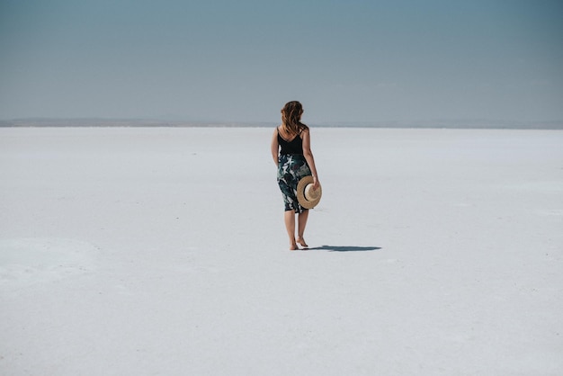 Photo rear view of young woman standing on field against sky