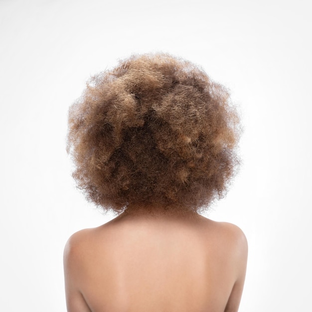 Rear view of a young woman Young caucasian brunette Girl on the background of the sea Curly hair